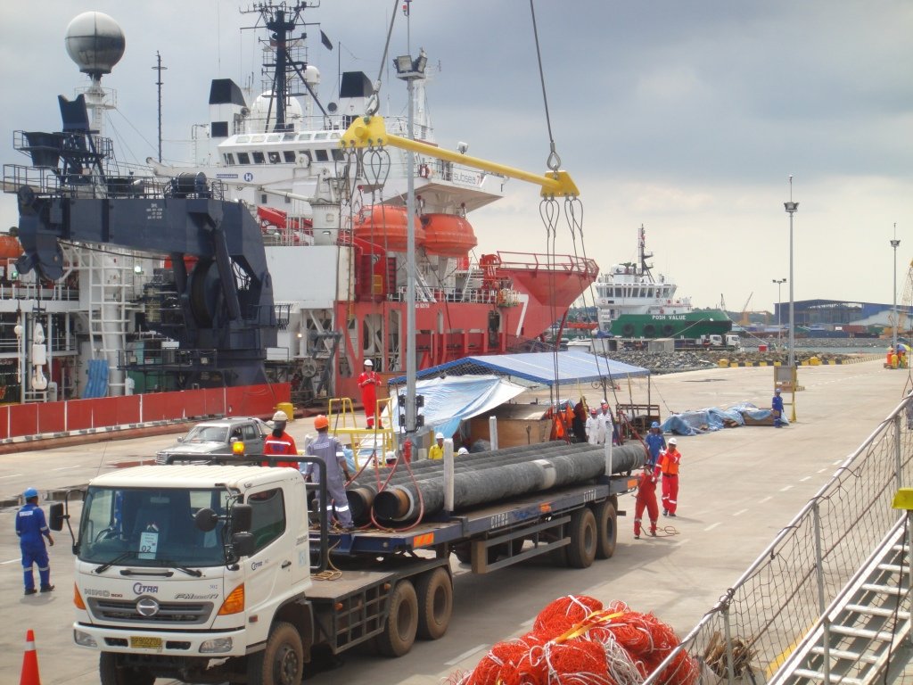 Truck loading pipe cargo at port